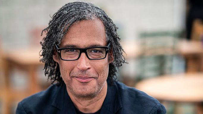 David Olusoga looks down the camera smiling