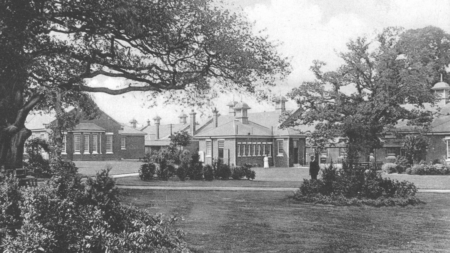A black and white photo of Manor Asylum with gardens in the foreground